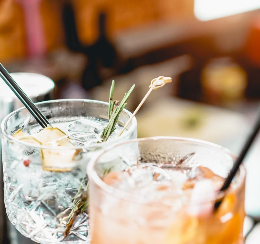 cocktails-served-on-bar-counter-prepared-with-gin-rosemary-paper-and-picture-id1182723702